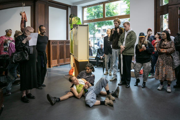 Performative reading by Emil Ertl and Pooja Patel during the opening 17.7.2025, written and conceived by Krys Huba, All of those records; tell me, bee, Künstlerhaus Bethanien, Berlin, 2025. Image courtesy of the artist and Künstlerhaus Bethanien, Berlin. Photo: Galya Feierman.