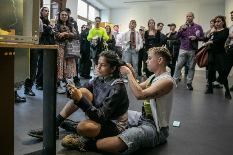 Performative reading by Emil Ertl and Pooja Patel during the opening 17.7.2025, written and conceived by Krys Huba, All of those records; tell me, bee, Künstlerhaus Bethanien, Berlin, 2025. Image courtesy of the artist and Künstlerhaus Bethanien, Berlin. Photo: Galya Feierman.
